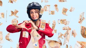 Ragazza felice con il casco e banconote da 50 euro - foto Depositphotos - SiciliaNews24.it